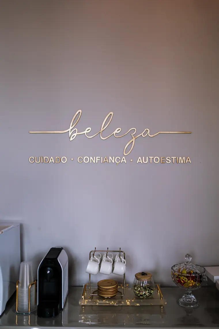 Espaço do café do studio, com painel dourado escrito beleza