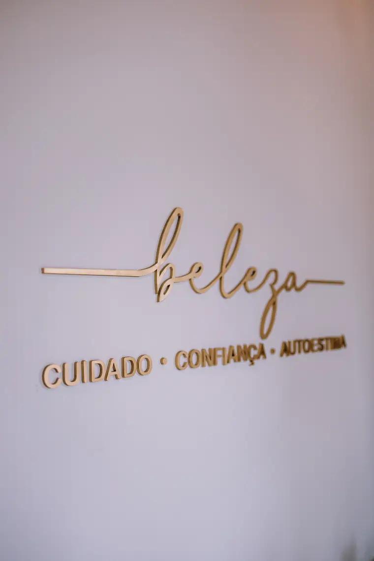 Painel dourado na parede: beleza, cuidado, confiança, autoestima